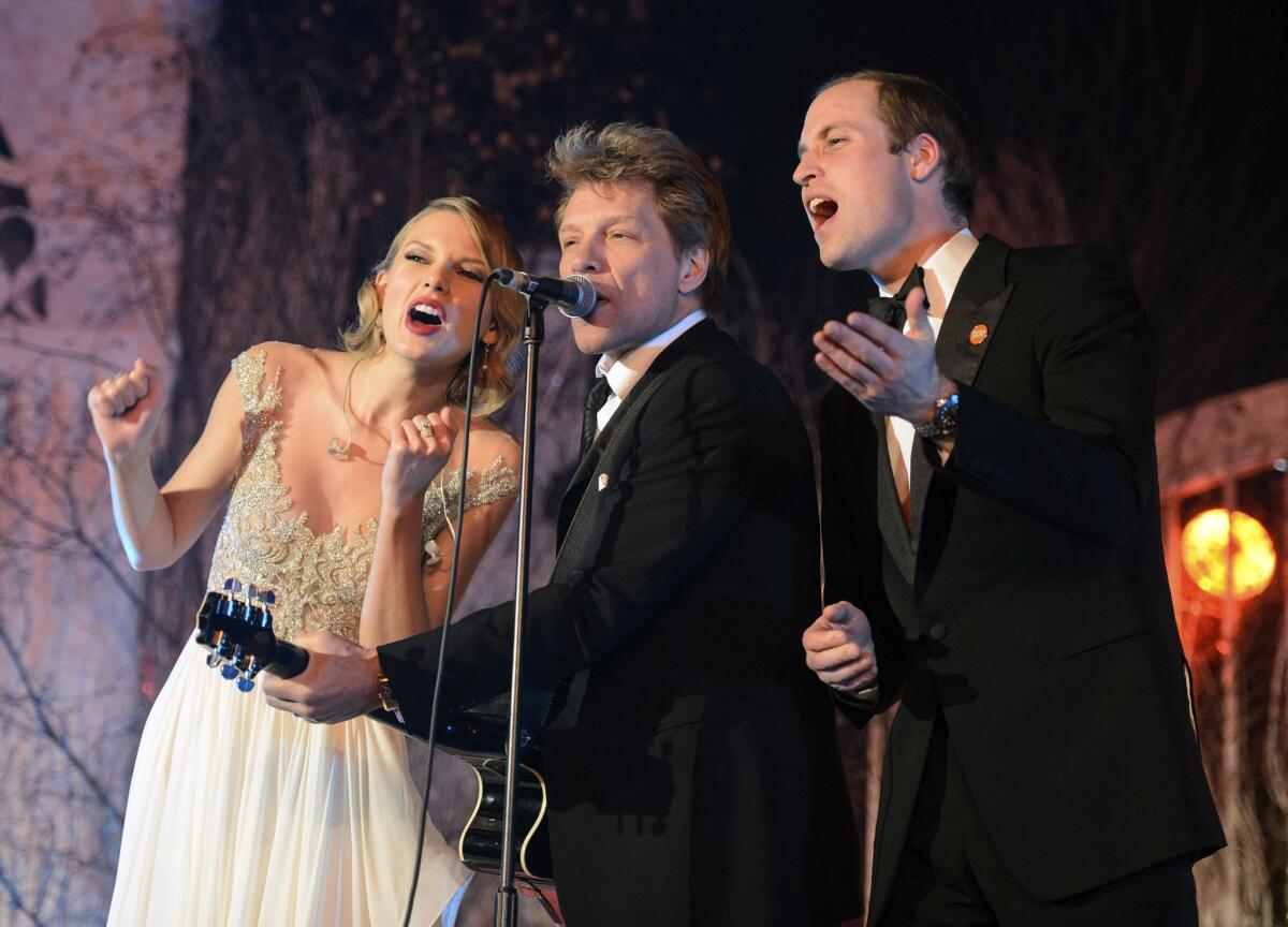Britain's Prince William, right, sings with Taylor Swift and Jon Bon Jovi at the Centrepoint Gala Dinner at Kensington Palace in London on Tuesday.