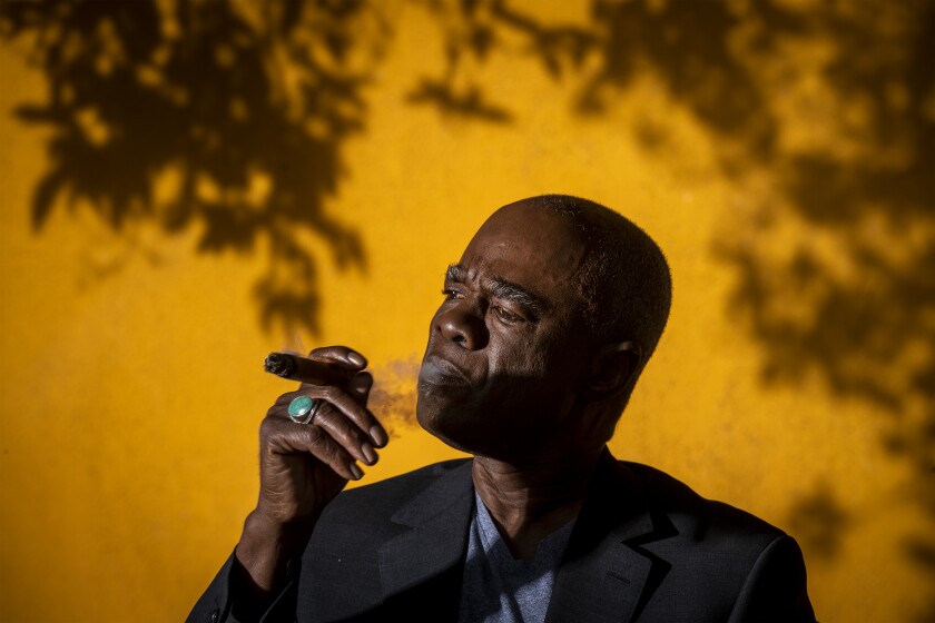 "Fargo" and "Ma Rainey's Black Bottom" actor Glynn Turman smoking a cigar in front of a yellow wall.
