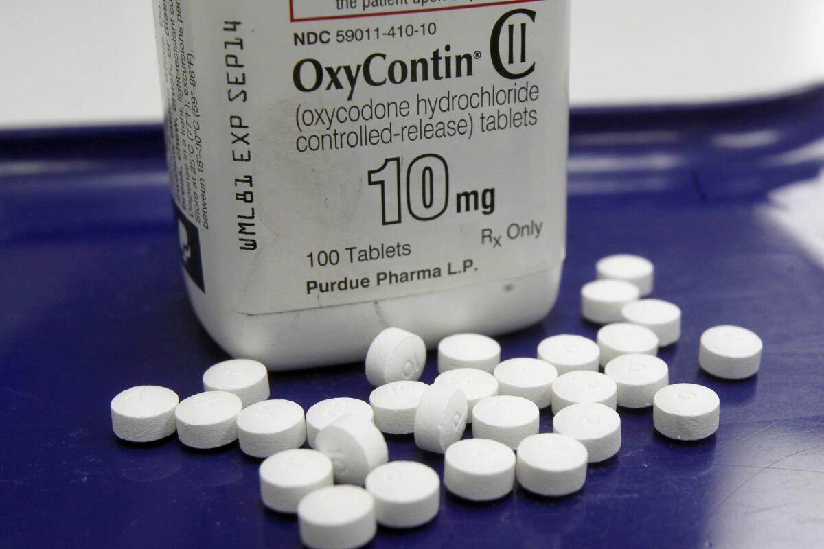 OxyContin pills in front of a bottle.