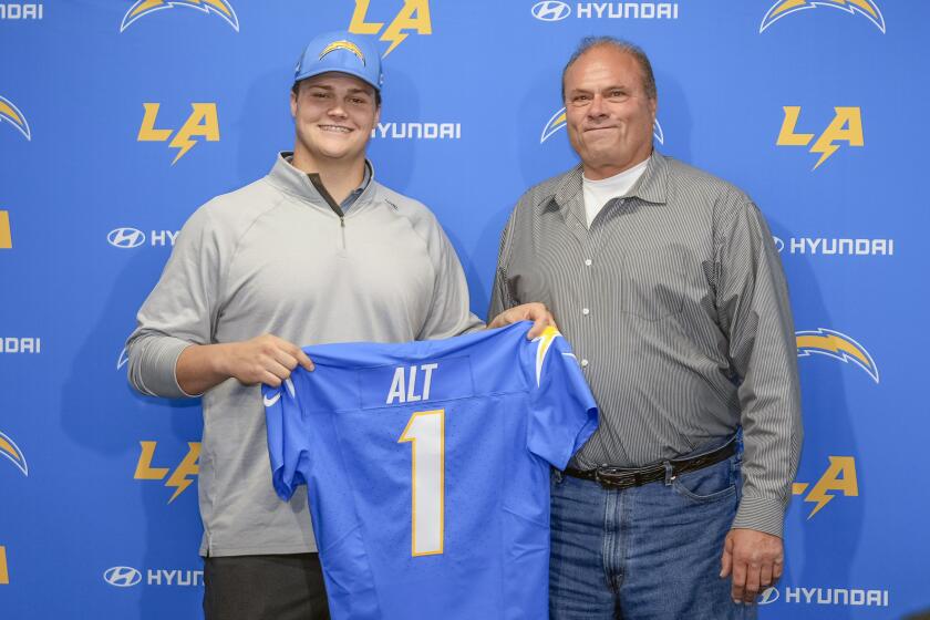 Los Angeles Chargers draft Joe Alt, left, and his father John Alt, right, pose for a photo.