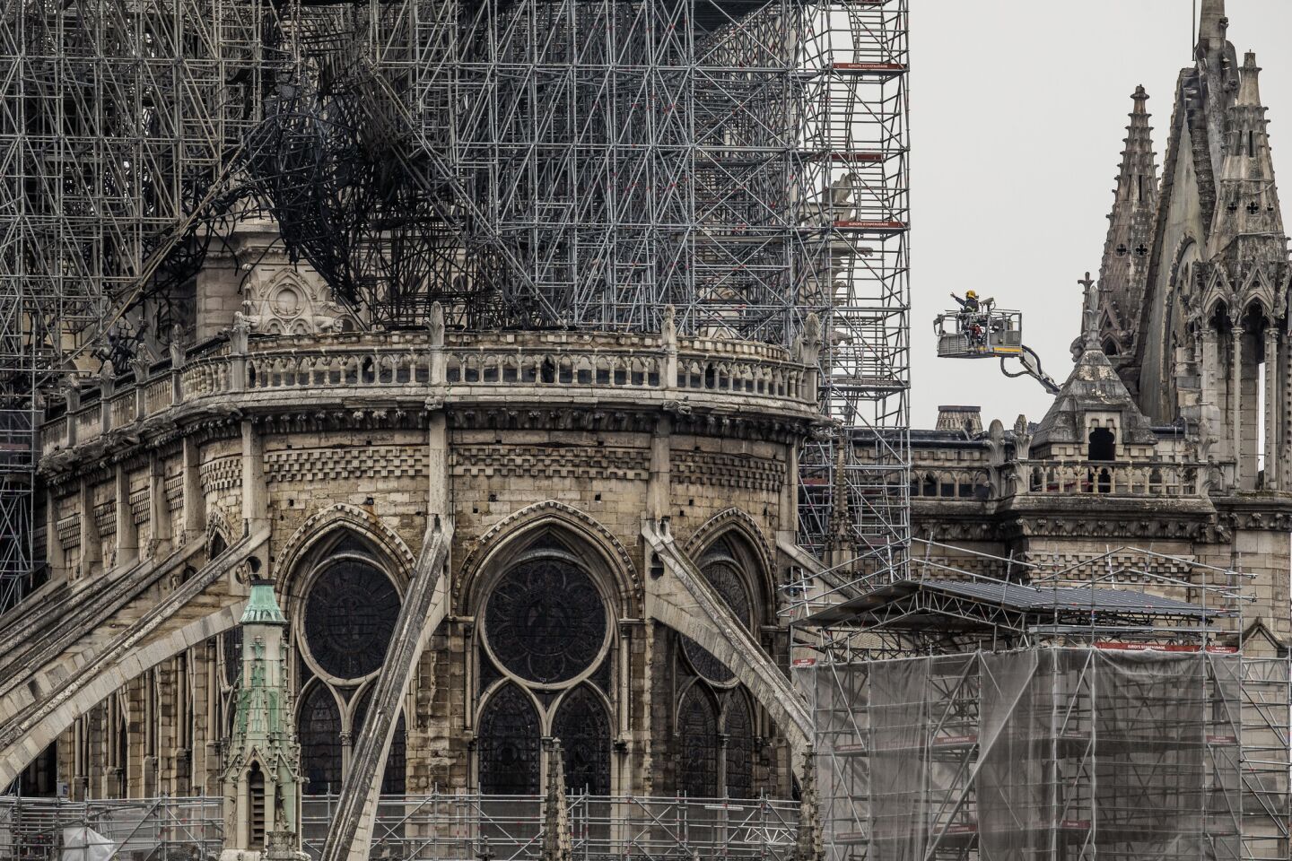 Workers inspect damage. The cathedral's flying buttresses are seen at left and in the foreground. The slanted supports were invented at the cathedral to provide support to an "exceptionally tall structure," says USC history professor Carolyn M. Malone.