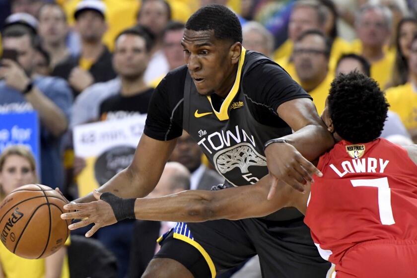 Toronto Raptors guard Kyle Lowry (7) reaches for the ball controlled by Golden State Warriors center Kevon Looney during the first half of Game 6 of basketballs NBA Finals, Thursday, June 13, 2019, in Oakland, Calif. (Frank Gunn/The Canadian Press via AP)