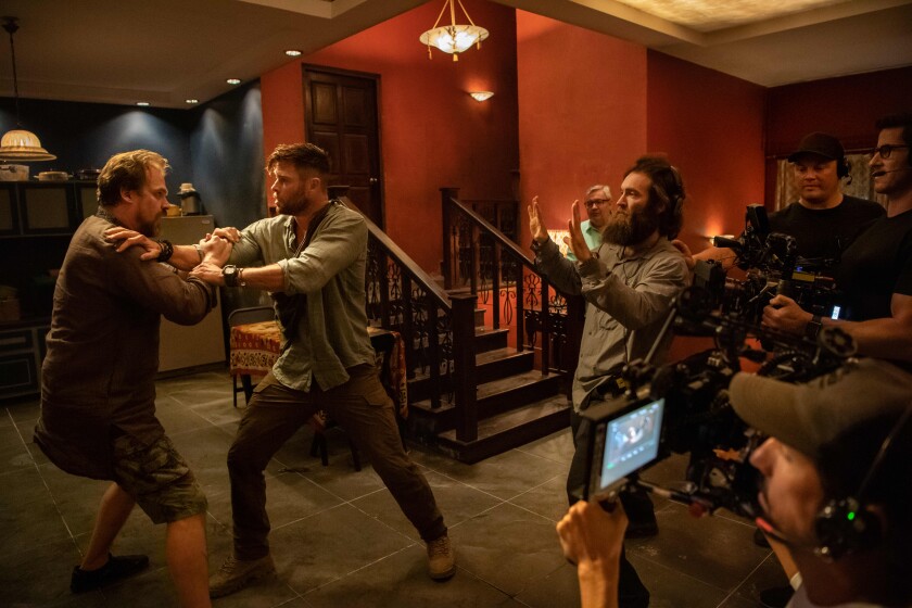 David Harbour, left, and Chris Hemsworth with director Sam Hargrave on the set of "Extraction"