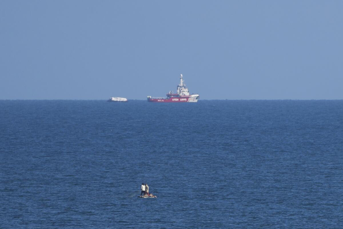 Un barco de la ONG Open Arms se acerca a la costa de Gaza remolcando una barcaza 