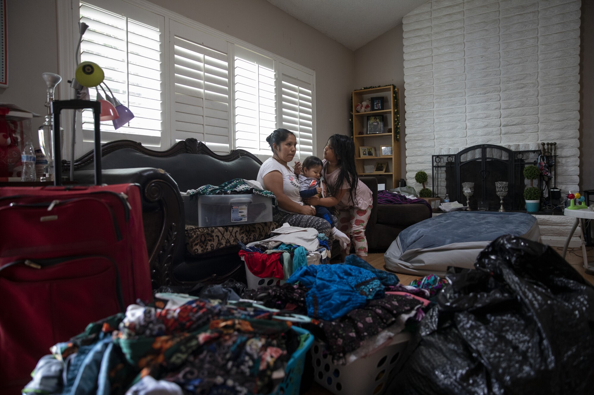 María Pérez, left, pauses from packing after looking at photos of her husband.
