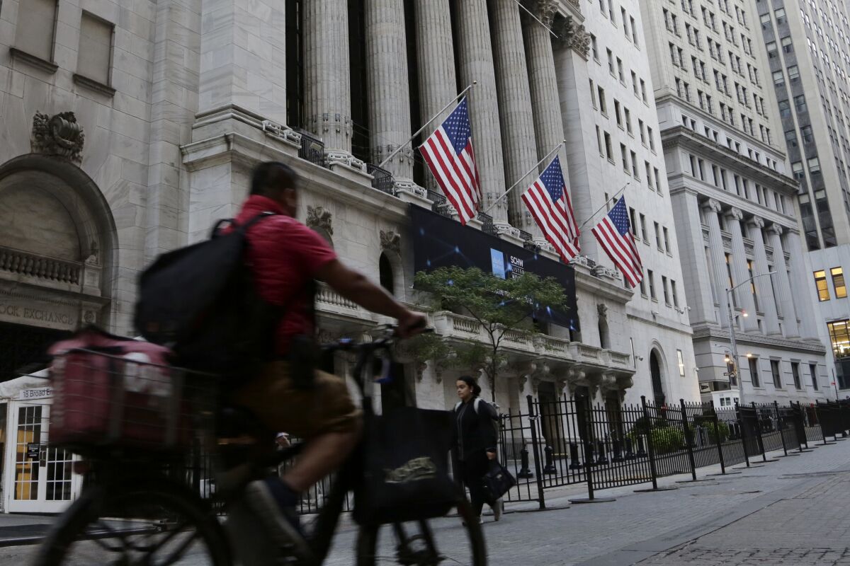 A man bikes past the New York Stock Exchange