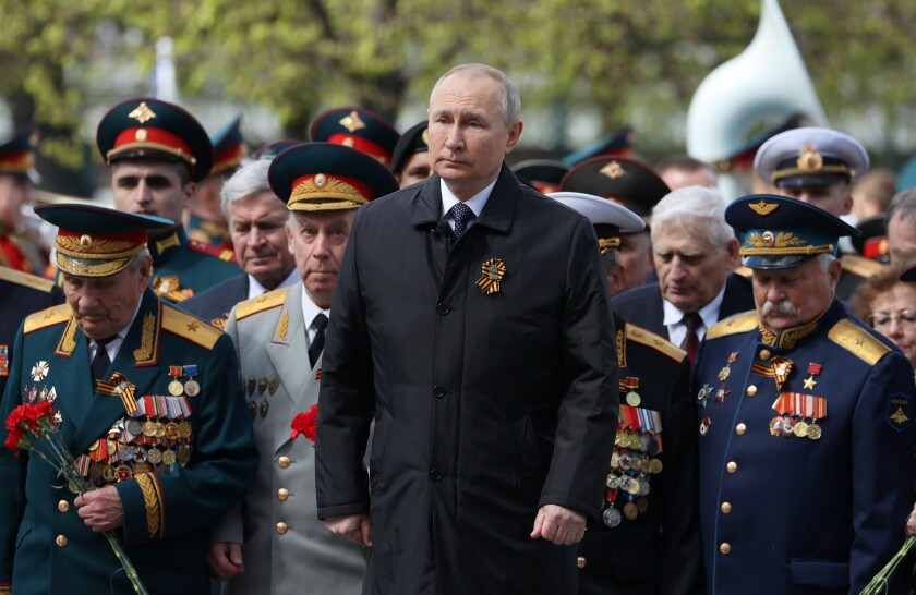 Russian President Vladimir Putin standing among the military brass