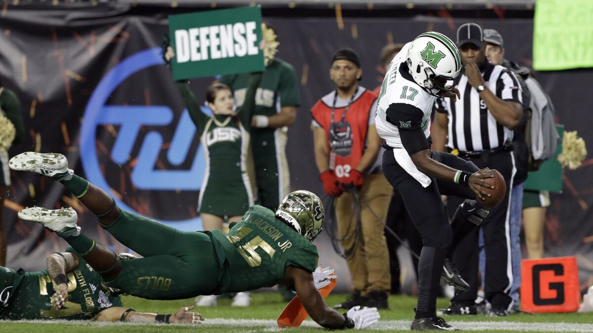 Marshall quarterback Isaiah Green (17) eludes South Florida defensive end Vincent Jackson Jr. (15) on an 11-yard touchdown run during the first half of the Gasparilla Bowl.