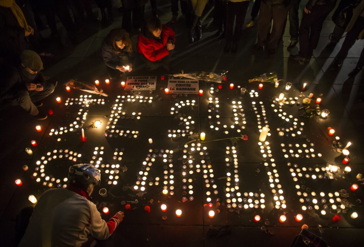People light candles at the Place de la Republique in Paris.