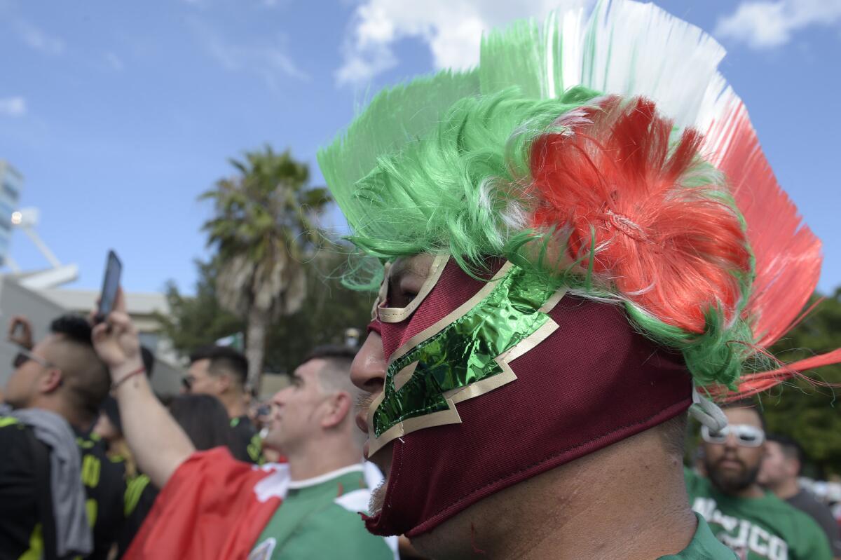 Saul Hernandez, right, of Sarasota, Fla., watches the Mexico team arrive by bus at the Orlando Citrus Bowl before a friendly soccer match against Costa Rica in Orlando, Fla., Saturday, June 27, 2015. (AP Photo/Phelan M. Ebenhack)