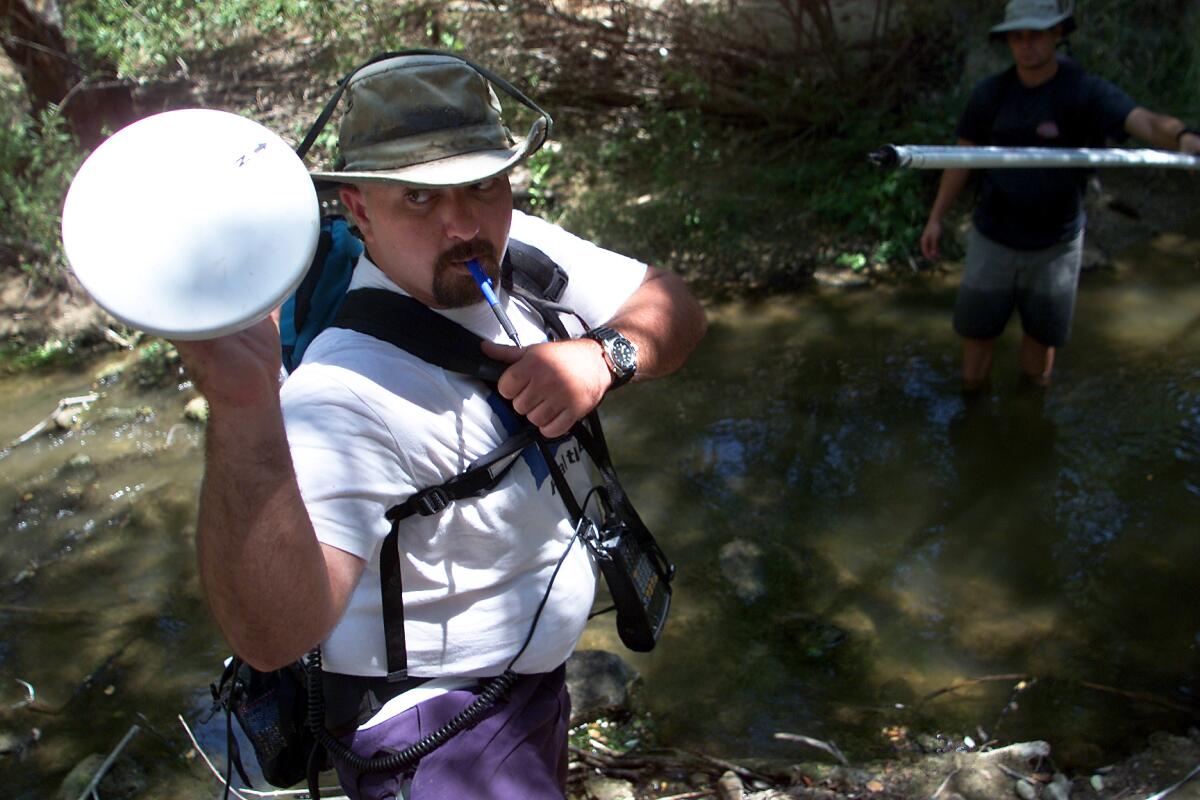 George Wilhelm x23486   Heal the Bay stream team coordinator Mark Abramson, left, reaches for the antenna of his global satellite positioning system after taking measurements at a small pool on Las Virgenes Creek. For the past year and a half, Heal the Bay has been sending volunteers out to various parts of 110squaremile area that makes up the Malibu Creek watershed to test water samples and seach for possible sources of pollution that trickle downstream.