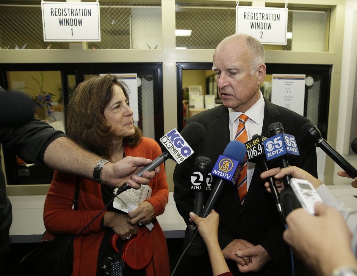 California Gov. Jerry Brown and his wife Anne Gust talk with reporters after voting at the Alameda County Registrar of Voters office Thursday, Oct. 30, 2014, in Oakland, Calif.