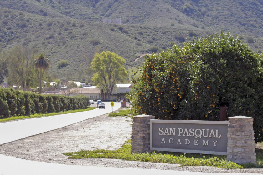 A car drives on the road leading to San Pasqual Academy 