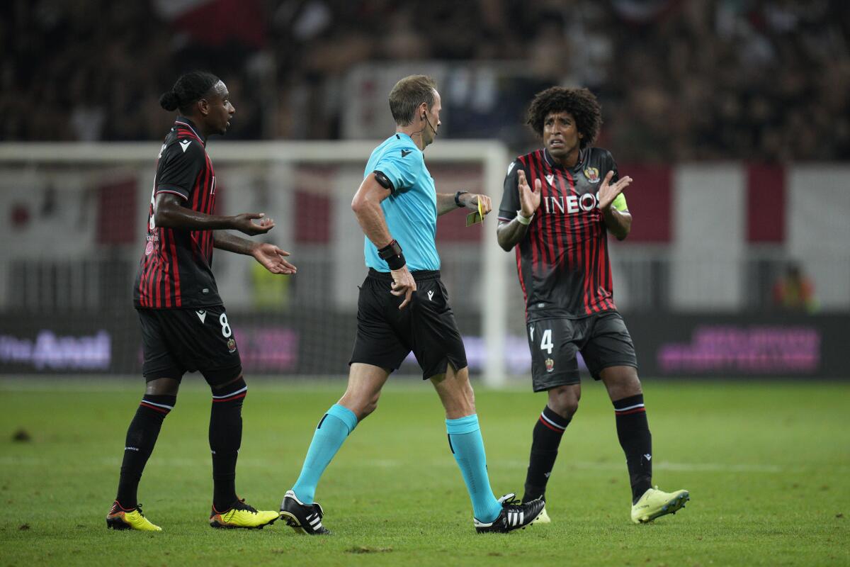 Nice's Dante, right, reacts as Referee Sascha Stegemann, centre, going to show Nice's Amine Gouiri a red card during the Europa Conference League play-off, second leg soccer match between Nice and Maccabi Tel Aviv at the Allianz Riviera stadium in Nice, France, Thursday, Aug. 25, 2022. (AP Photo/Daniel Cole)