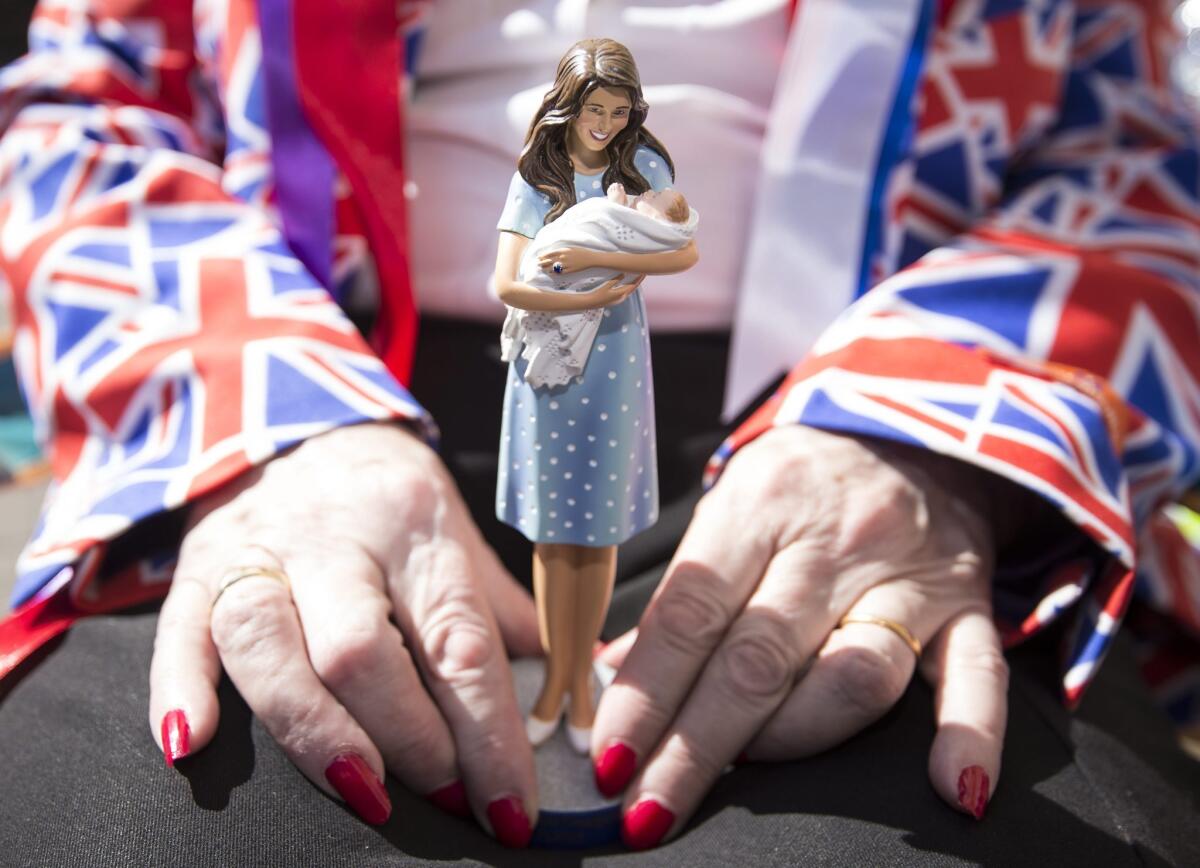 A royal fan holds a figurine of the duchess of Cambridge outside St. Mary's Hospital on April 21, 2015.