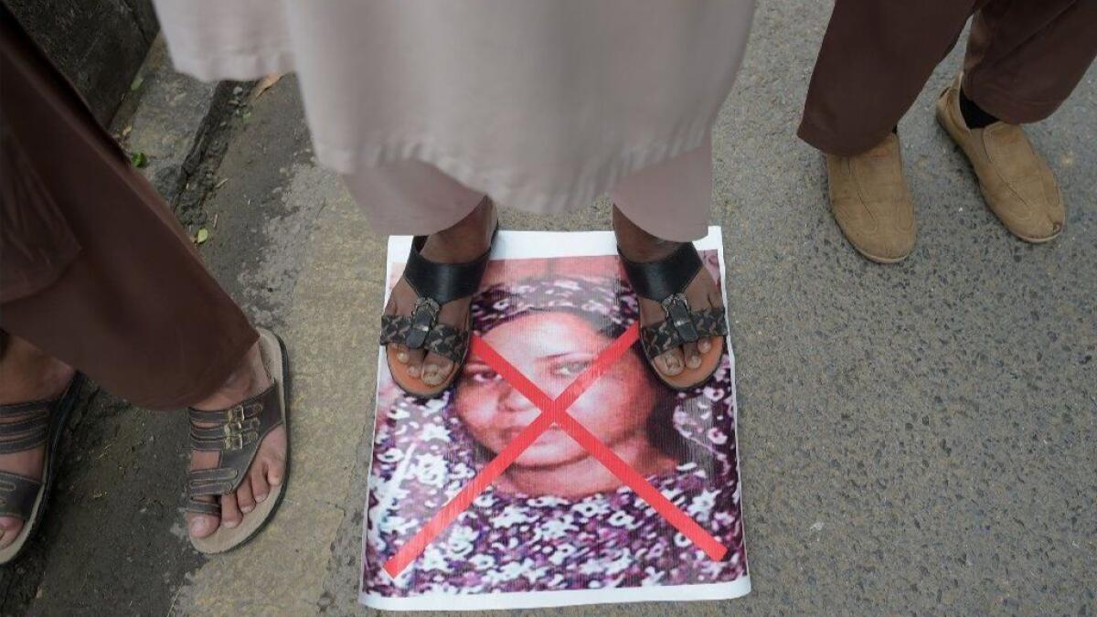 A supporter of a Pakistani Islamist party stands on an image of Christian woman Asia Bibi during a protest against her acquittal of blasphemy charges in November 2018.