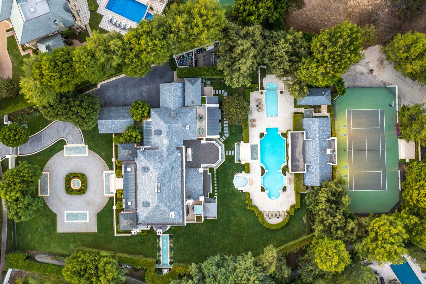 Aerial view of the estate showing the home, pool, tennis court and driveway.