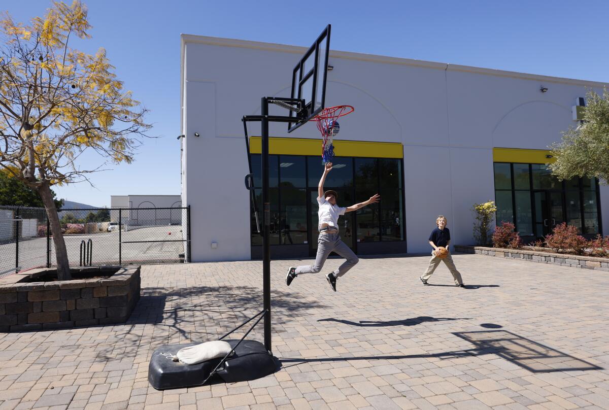 Andrew Sunderland, left, and Elijah Gott play basketball during recess at Heart Christian Academy.