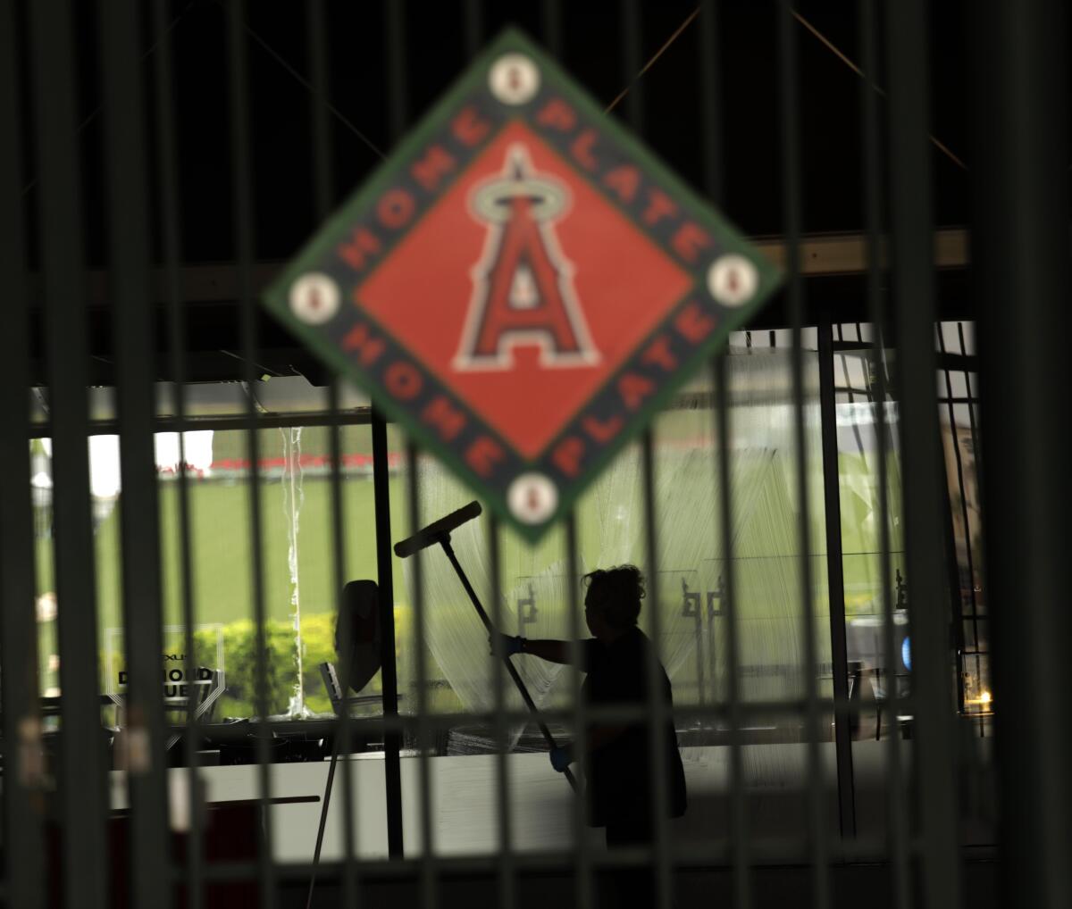 A worker washes a window inside Angel Stadium on May 23.