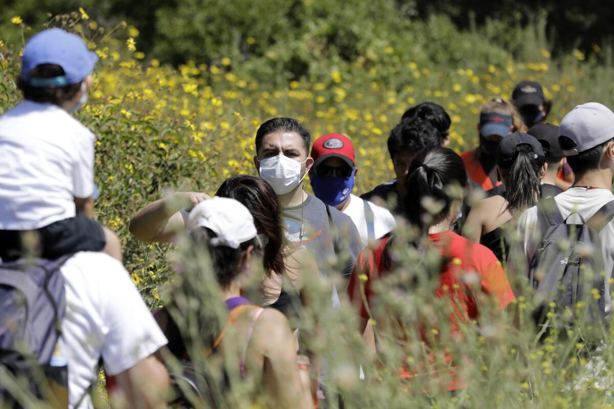 Visitors share a narrow hiking path at Eaton Canyon Natural Area Park on Sunday in Pasadena.