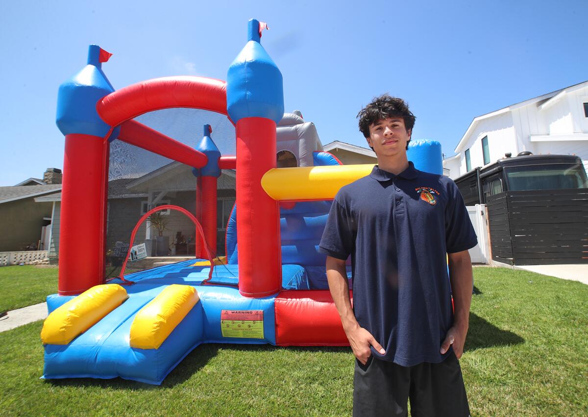Landon Leguina stands by an inflatable bounce house.
