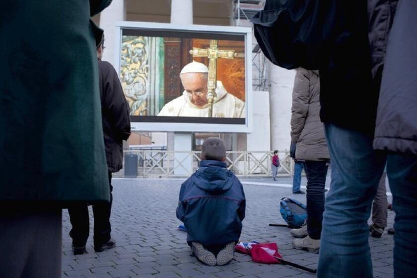 People gathered at St. Peter's Square watch Pope Francis' Mass with cardinals in the Sistine Chapel.