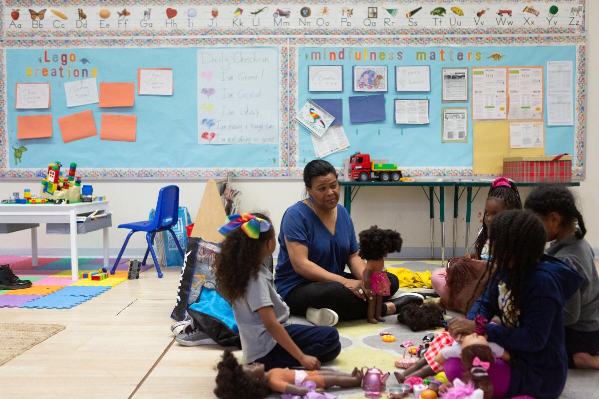 Renee Curry, a therapist, leads a group of girls during a doll play session at Crete Academy in South Los Angeles in March. 