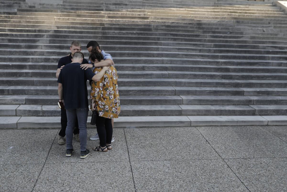 Friends pray in Louisville, Ky., on Tuesday.