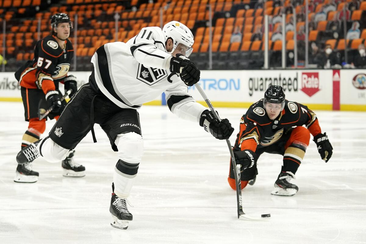 Kings center Anze Kopitar shoots as Ducks defenseman Ben Hutton defends.