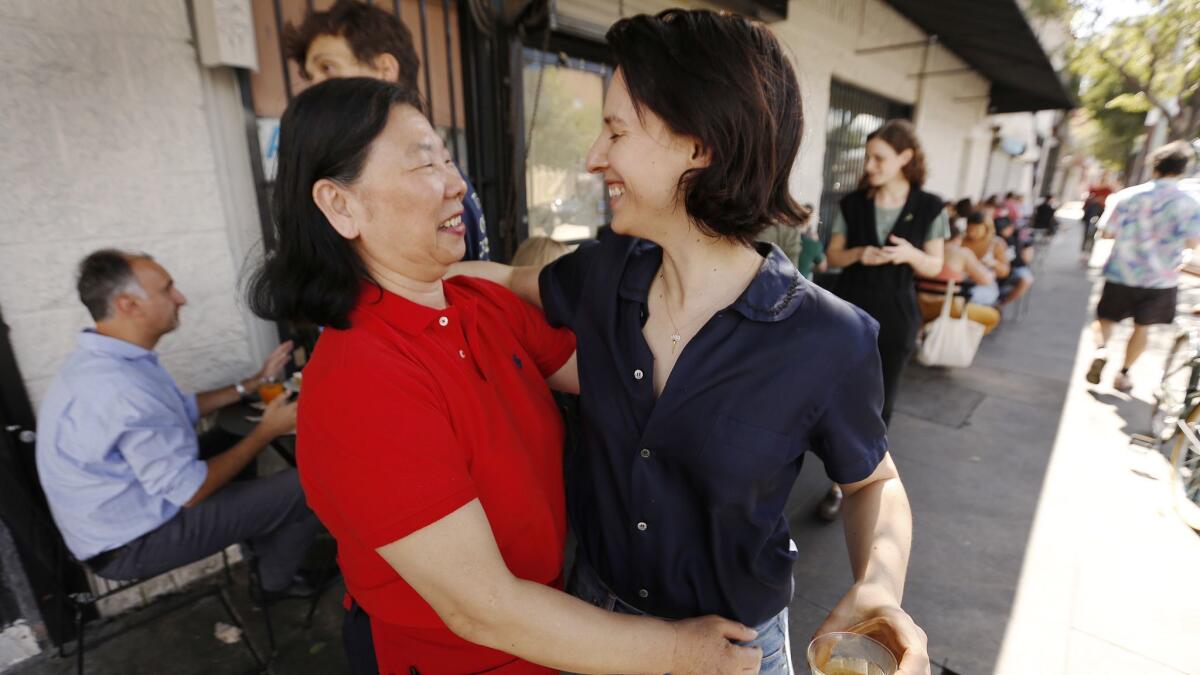 Lena Louie, left, owner of Wah’s Golden Hen, hugs Jessica Koslow, owner of Sqirl, at Sqirl, which is located across the street from Wah's on Virgil Avenue.