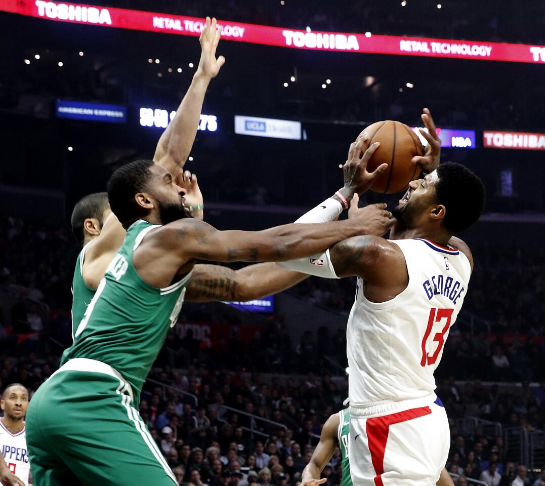 Clippers forward Paul George is fouled en route to the basket by Celtics guard Kemba Walker during the second quarter of a game Nov. 20 at Staples Center.