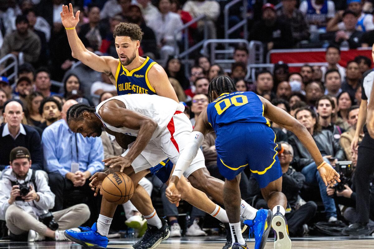 Clippers forveti Kawhi Leonard, Warriors guardı Klay Thompson ve forveti Jonathan Kuminga tarafından ikili takım halinde dribling yapıyor.