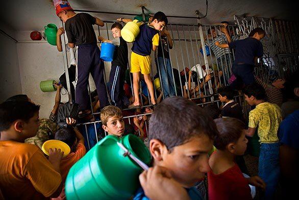 Palestinian children in the West Bank city of Hebron scramble to get a ration of donated food from the Islamic Waqf during the Islamic month of Ramadan. Muslims throughout the world mark the holy month by refraining from eating and drinking from dawn until dusk.