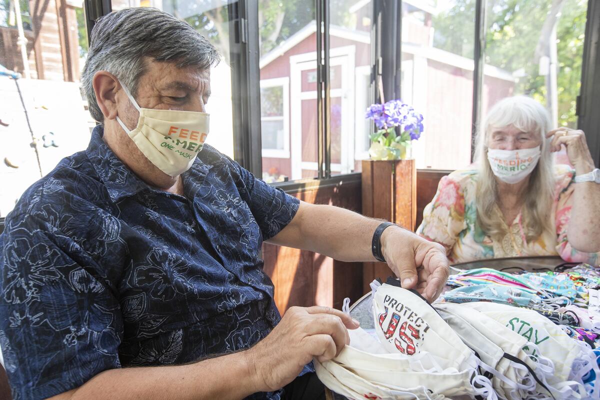 Ted Engard and his wife Peggy show a special hand painted mask at his home on Tuesday.
