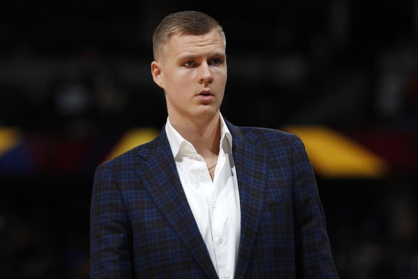 FILE - In this March 14, 2019, file photo, Dallas Mavericks forward Kristaps Porzingis stands during the second half of the team's NBA basketball game against the Denver Nuggets in Denver. An attorney for Porzingis acknowledges that a woman has accused the NBA star of rape, but unequivocally denies the allegation. Lawyer Roland Riopelle said Saturday, March 30, that the claim against the Dallas Maverick was part of an extortion attempt that is being investigated by the FBI. (AP Photo/David Zalubowski, File)