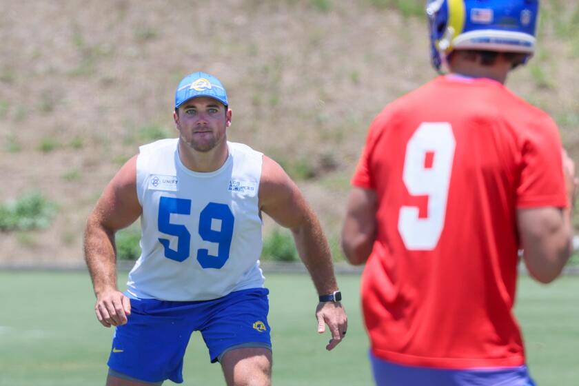 Rams linebacker Troy Reeder keeps an eye on quarterback Matthew Stafford during  practice.