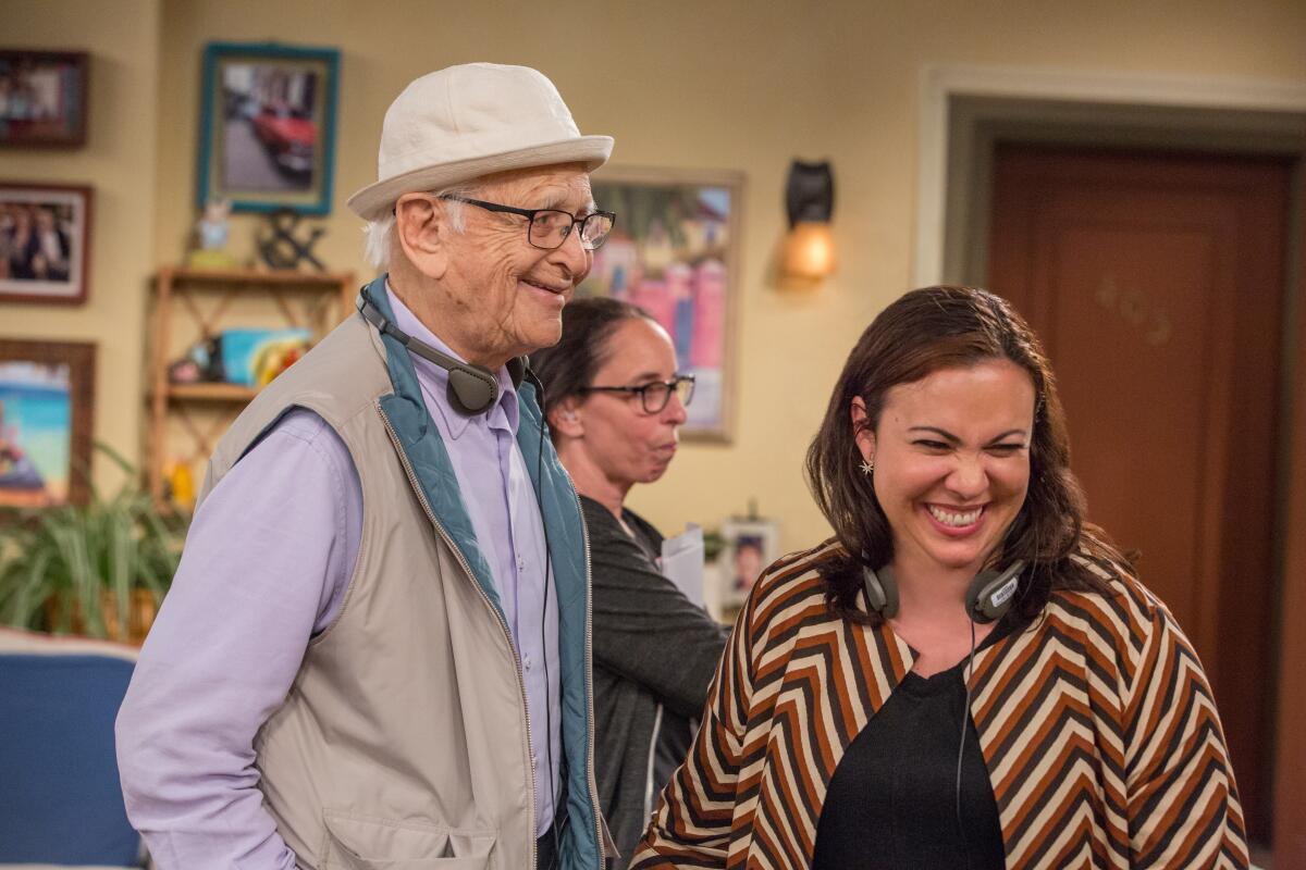 Norman Lear with Gloria Calderon Kellett on a studio set.