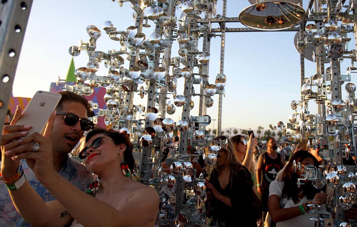 INDIO, CALIF. - APRIL 14, 2017. Crowds of people take photos of an art installation called "Lamp Beside The Golden Door" on day one of the Coachella Music and Arts Festival in Indio on Friday, April 14, 2017. (Luis Sinco/Los Angeles Times)