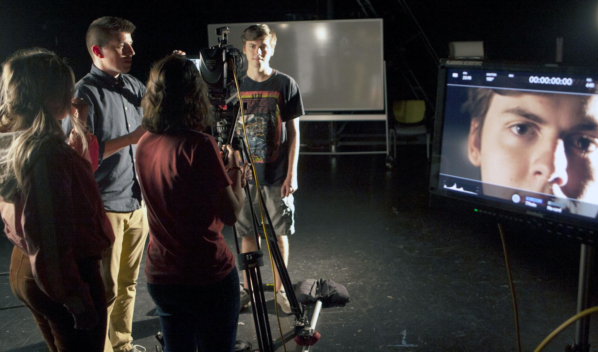 Professor George Simon of John Paul the Great Catholic University helps film students set up a camera for a scene.