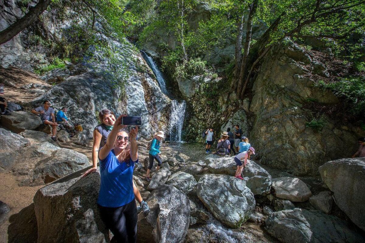 Hikers take photos and explore the Monrovia Canyon Falls in Monrovia, Calif.