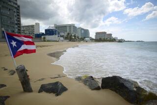 FILE - A Puerto Rican flag flies on the shore at Ocean Park, in San Juan, Puerto Rico, Thursday, May 21, 2020. A ruling by Puerto Rico’s Supreme Court on Wednesday, March 15, 2023, upholds the decision of an appeals court that voids a document from 2020 that regulates land use and the granting of permits on the island, throwing into limbo hundreds of thousands of business and construction permits. (AP Photo/Carlos Giusti, File)