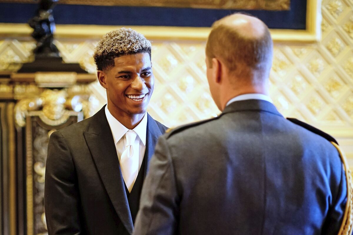 Footballer Marcus Rashford is made an MBE (Member of the Order of the British Empire) by the Britain's Prince William during an investiture ceremony at Windsor Castle, England, Tuesday, Nov. 9, 2021. (Aaron Chown/PA via AP)