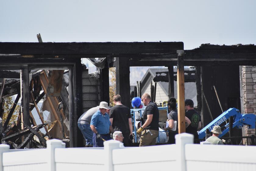 Investigators work at the scene Tuesday, Aug. 25, 2026, where a family was killed and the house burned in Billings, Mont. (AP Photo/Matthew Brown)
