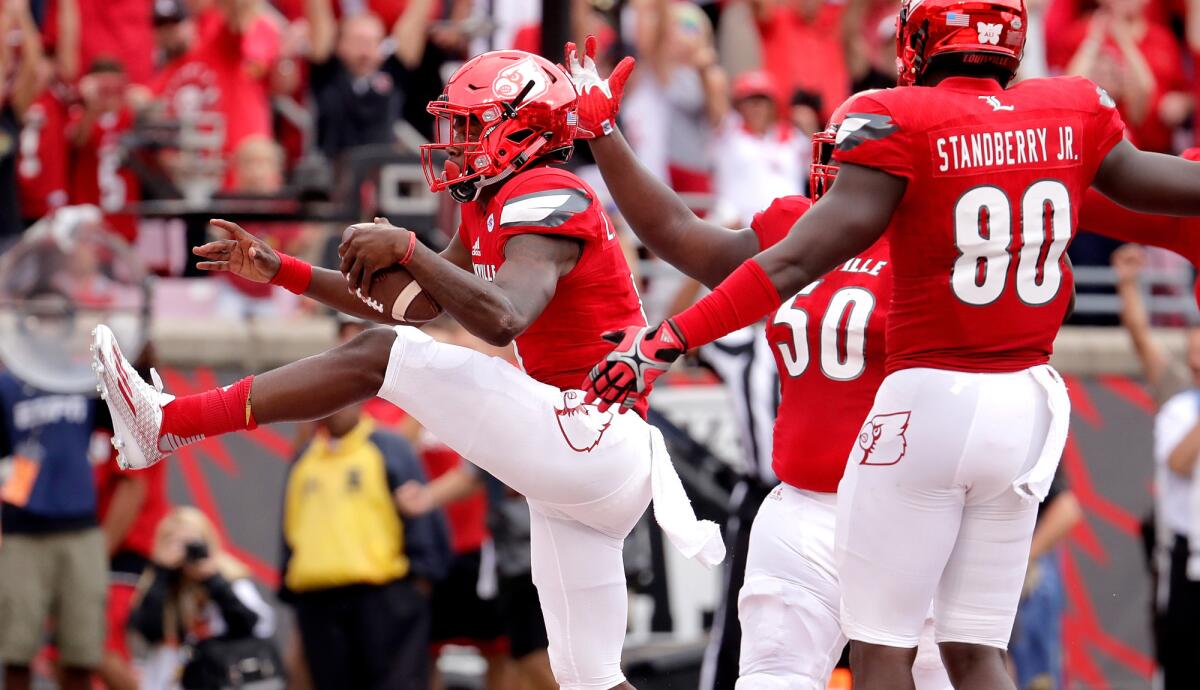 Louisville's Lamar Jackson celebrates with teammates after scoring one of his four touchdowns against Florida State on Saturday.