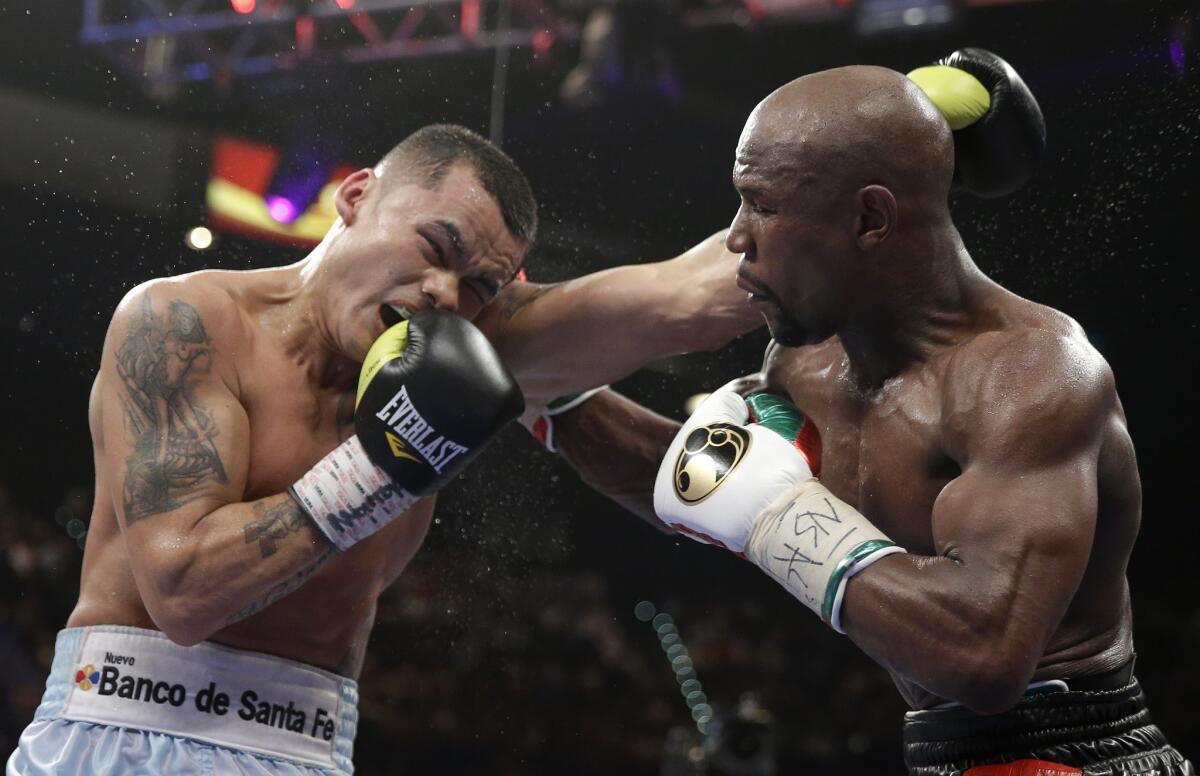 Marcos Maidana, left, and Floyd Mayweather Jr. trade blows during their welterweight unification title fight at the MGM Garden Arena in Las Vegas. Mayweather won the bout by majority decision.