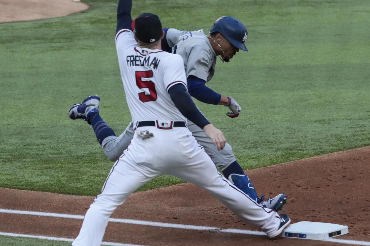 Dodgers' Mookie Betts beats the throw to Atlanta Braves first baseman Freddie Freeman.