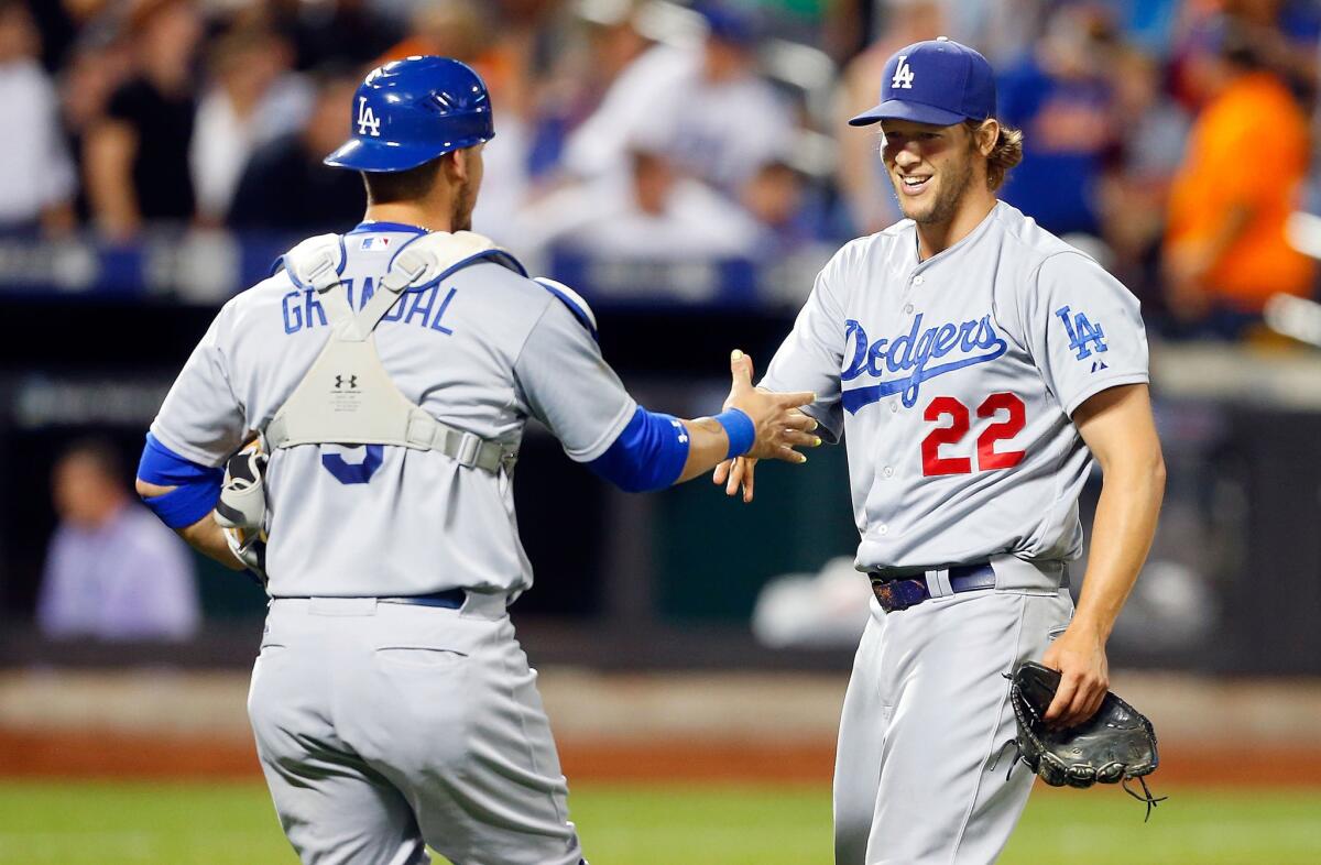 Dodgers pitcher Clayton Kershaw celebrates his 3-0 shutout of the Mets with catcher Yasmani Grandal.