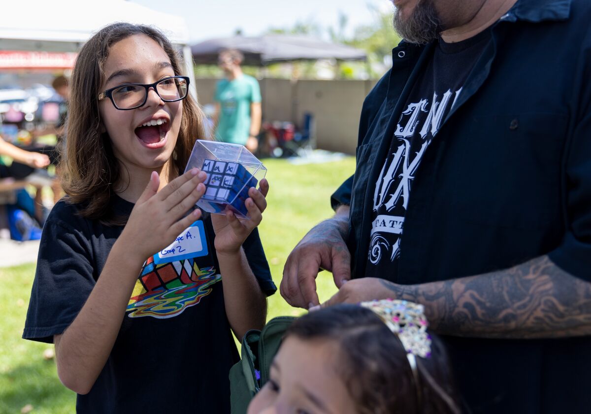 Penelope Almeida holds up her Rubik's Cube signed by Max Park, who holds multiple world records for his Rubik's Cube solves.
