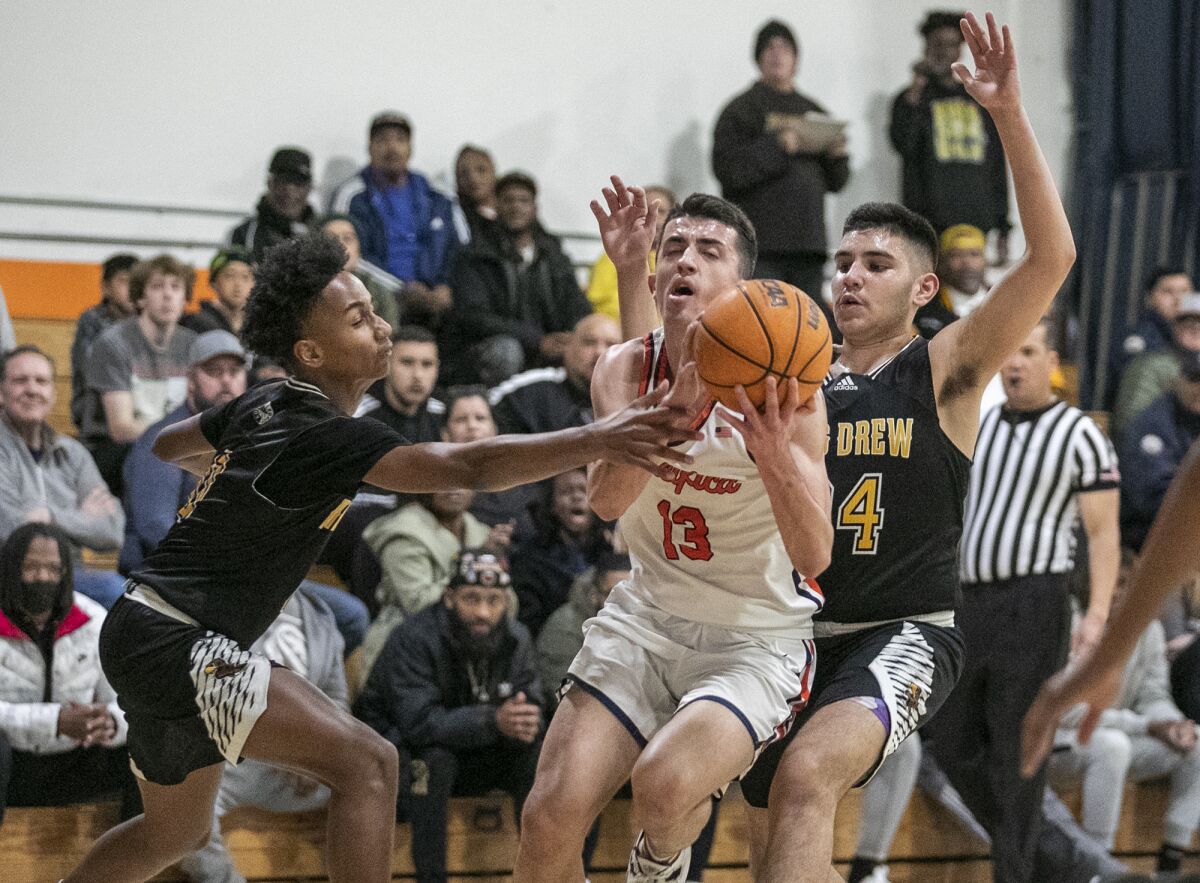 Pacifica Christian's Tanner Deal splits King-Drew defenders Josahn Webster, left, and Joshua Rivas on Thursday.