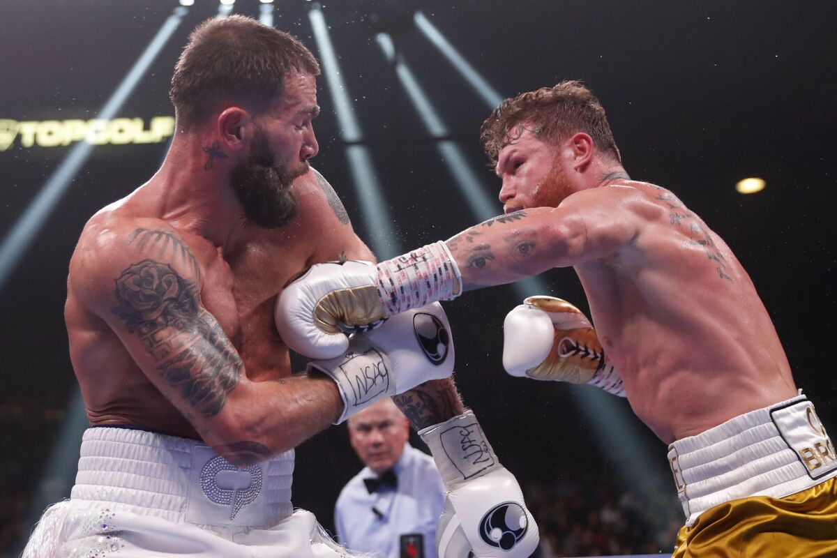 Canelo Álvarez, right, punches Caleb Plant during their fight in Las Vegas on Saturday.